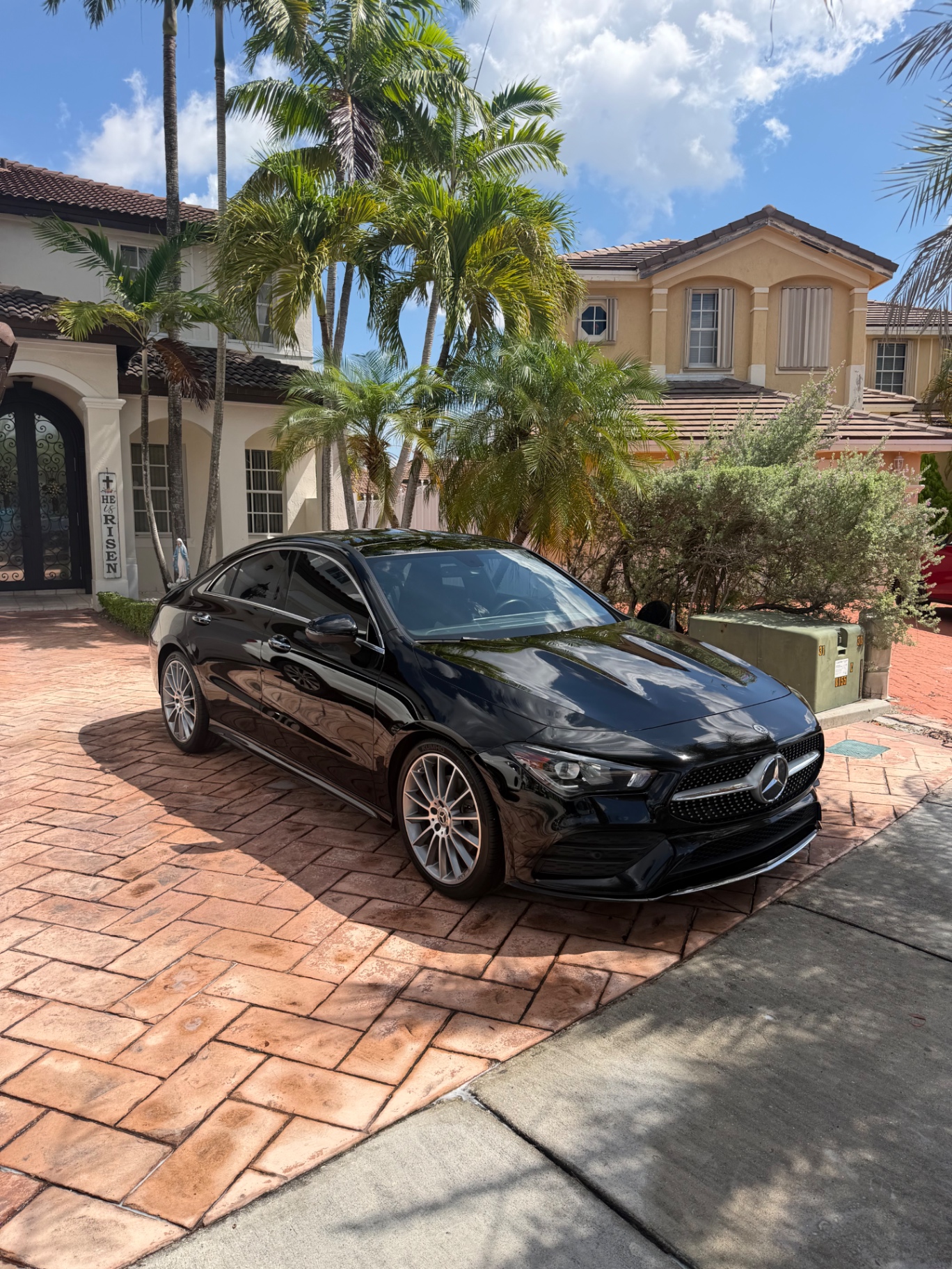 Glossy black Mercedes-Benz CLA detailed on a Miami driveway