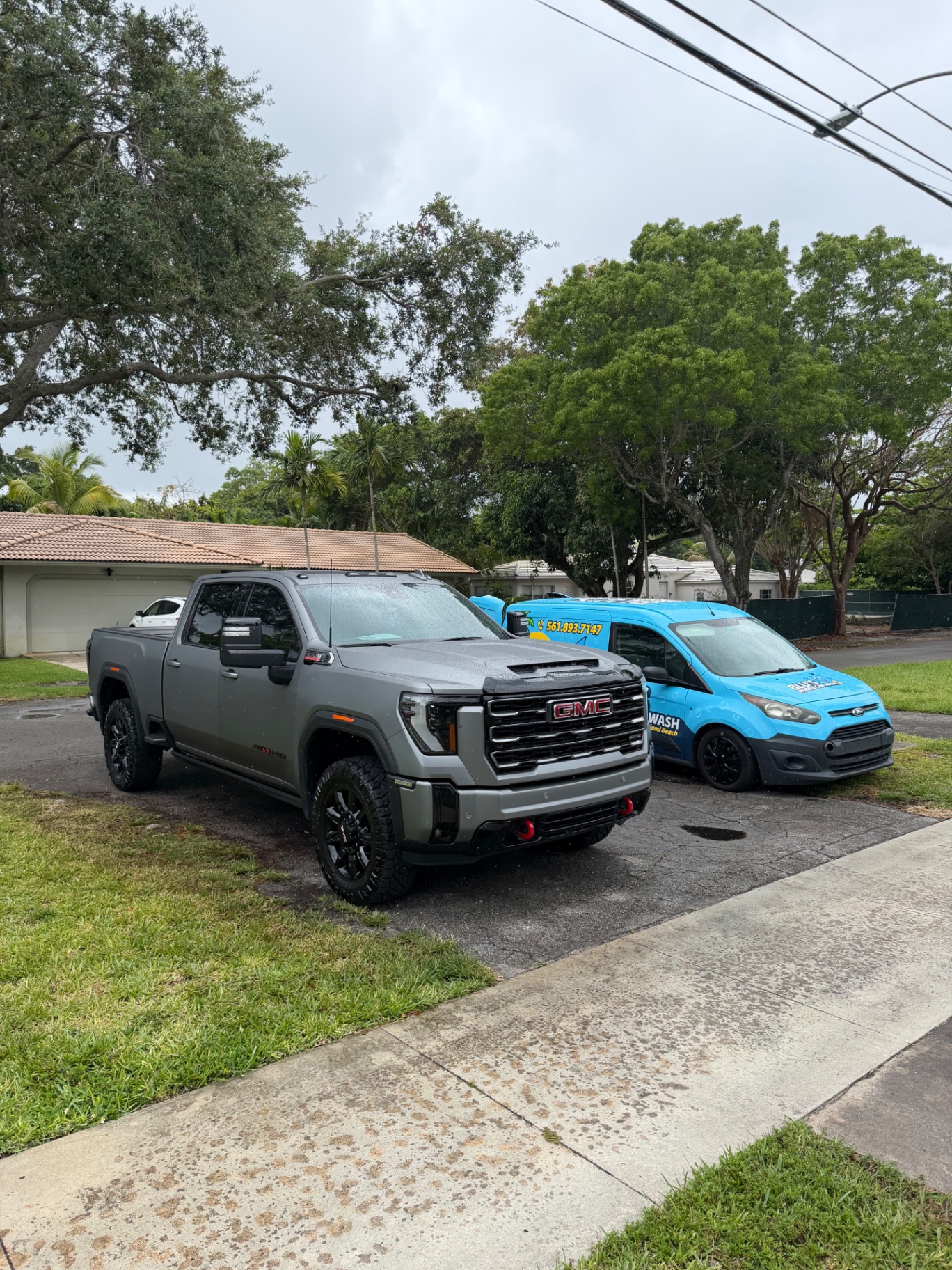 GMC Sierra AT4 detailed in the driveway with BLU'S van