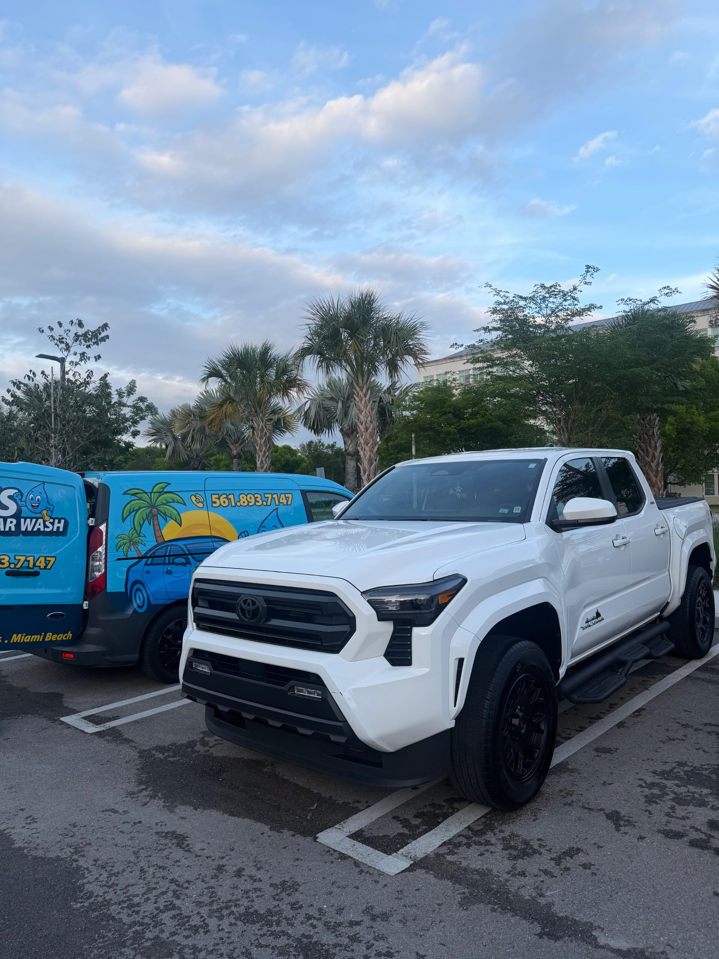 White Toyota Tacoma freshly detailed next to BLU'S van