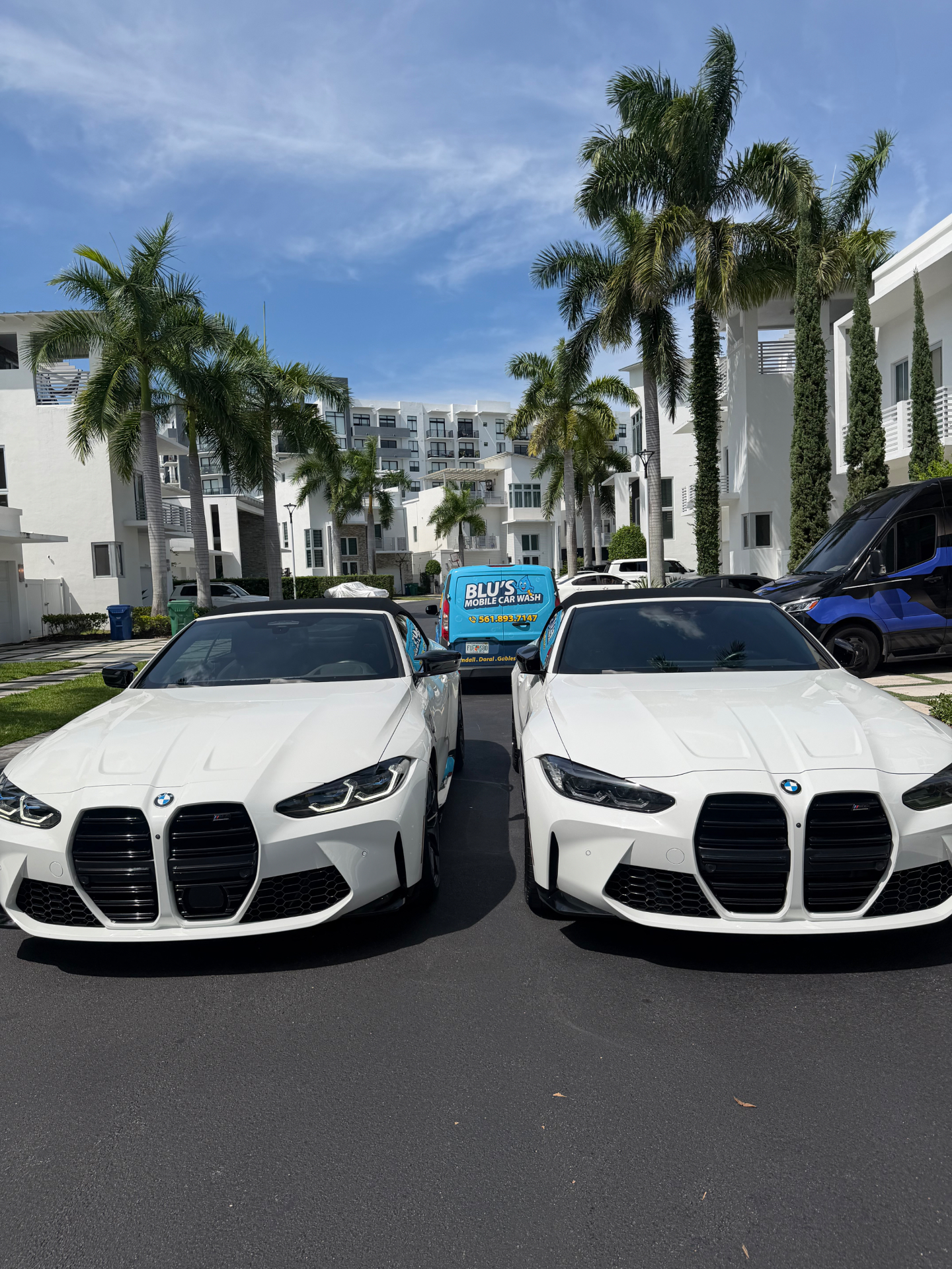 BLU'S mobile detailing van parked between two BMW M4s