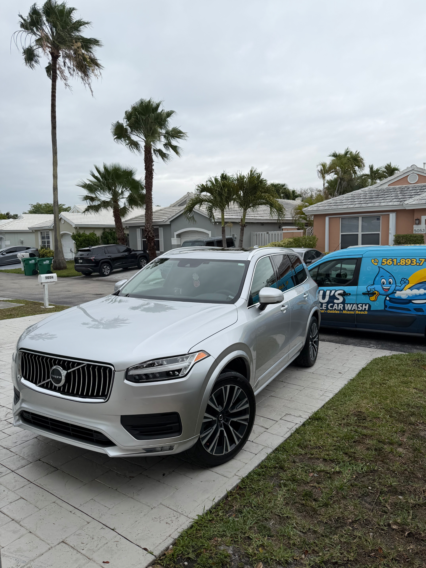 Silver Volvo XC90 detailed in a Florida driveway next to BLU'S van